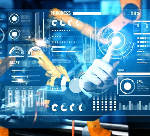 Un hombre interactúa con una interfaz digital mientras controla un brazo robótico en un entorno industrial.