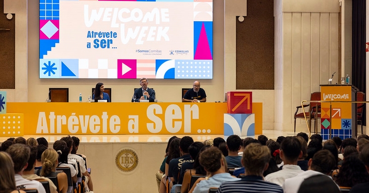 Un evento de bienvenida con un panel de oradores frente a una audiencia.