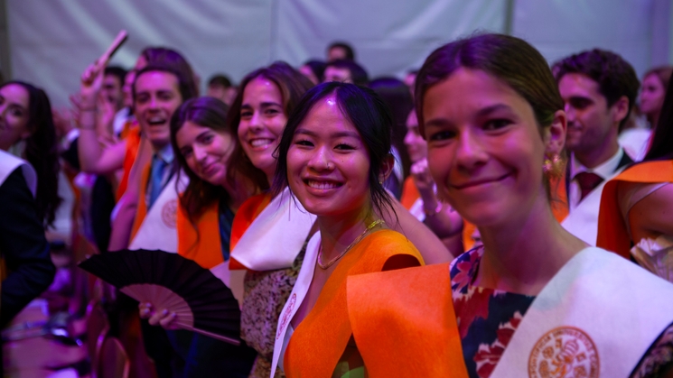 Group of young graduates smiling and celebrating at a graduation ceremony