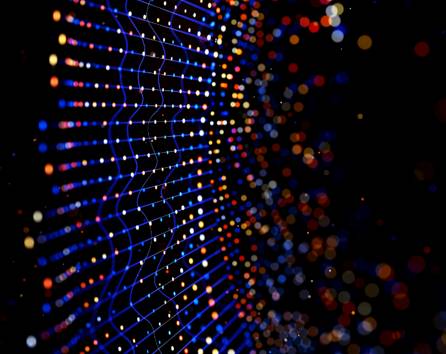 La imagen muestra un fondo abstracto con puntos brillantes en diferentes colores que crean una sensación de profundidad y movimiento.