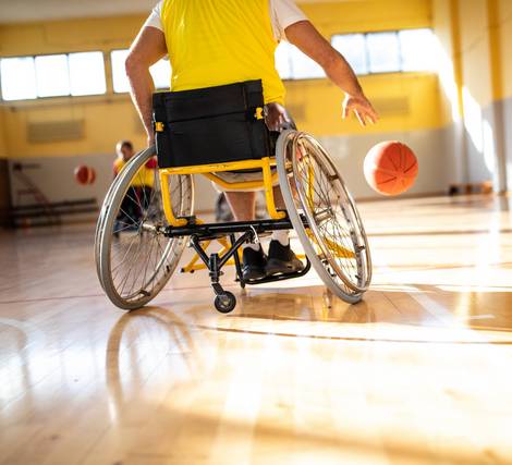 A person in a wheelchair playing basketball in an indoor court