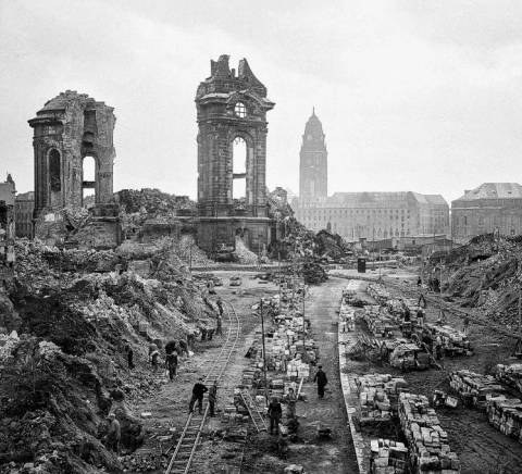 Una vista de un paisaje urbano en ruinas, con edificios destruidos y escombros en el suelo.