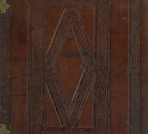 La imagen muestra la tapa de un libro antiguo con un diseño decorativo en relieve sobre cuero marrón.