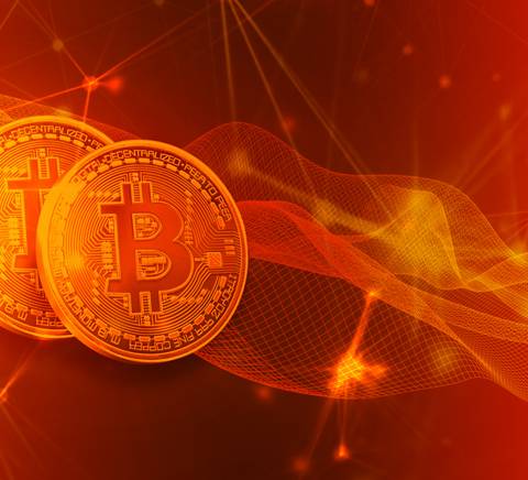 La imagen muestra dos monedas de Bitcoin sobre un fondo rojo con efectos de luz y ondas digitales.