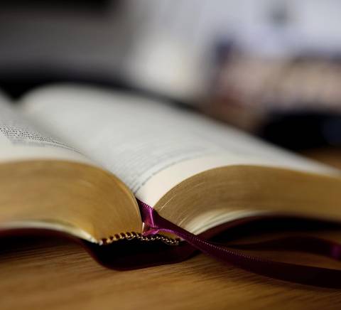 Un libro abierto sobre una mesa con una cinta de marcador visible.