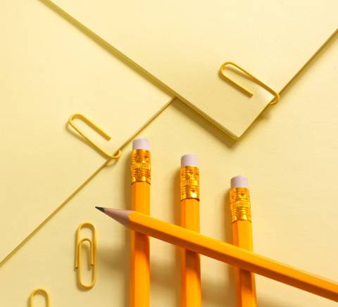 Una composición de útiles de escritura amarillos sobre un fondo amarillento.