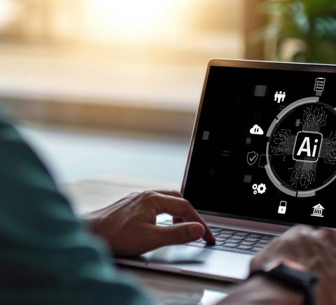 Una persona está trabajando en una computadora portátil con un diseño centrado en inteligencia artificial.