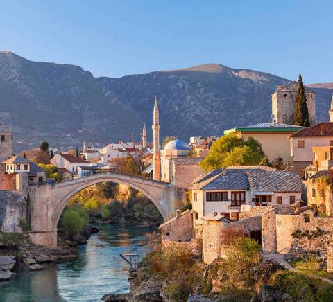 Vista panorámica del puente Stari Most en Mostar junto al río Neretva y edificios históricos.