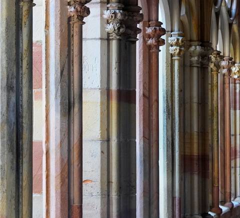 Vista de columnas de piedra con detalles arquitectónicos en un entorno histórico.