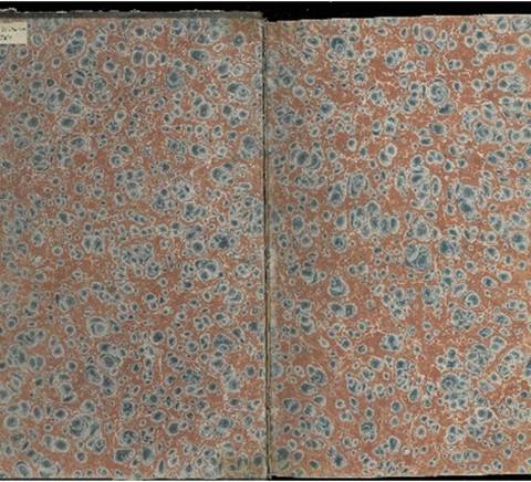 La imagen muestra un diseño de papel marmoleado con patrones de azul y rojo sobre fondo claro.