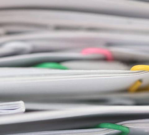 A close-up view of a stack of papers with various colored tags sticking out.