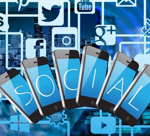 La imagen muestra varios teléfonos móviles con la palabra 'SOCIAL' destacada, rodeados de íconos de redes sociales.