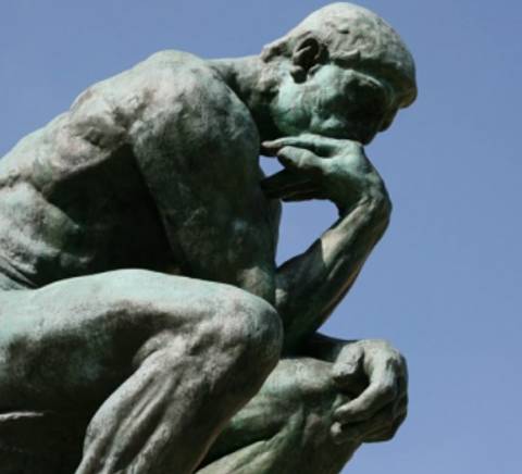 Una escultura de un hombre pensativo en una pose reflexiva.