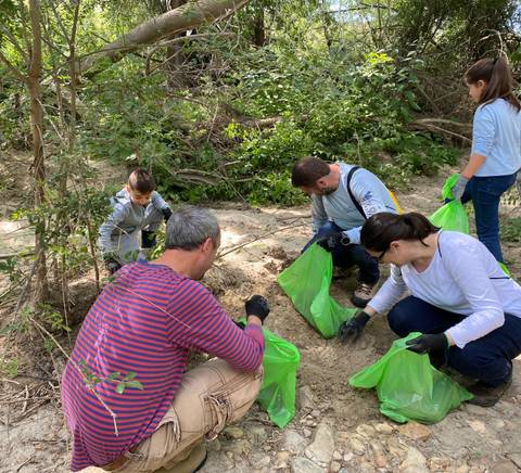 Group of people participating in a cleanup activity in a wooded area.