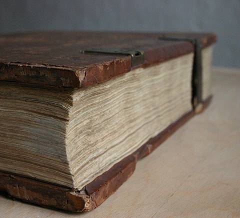 Un libro antiguo con cubiertas de cuero y páginas amarillentas.