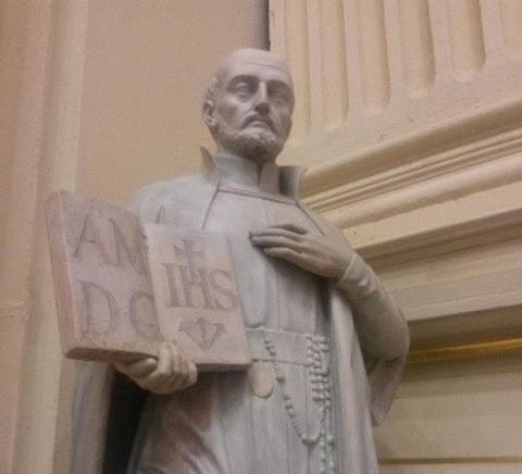 Escultura de un religioso sosteniendo un libro en la mano.