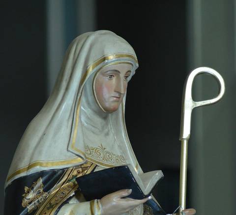 Una estatua de una figura religiosa con un libro en las manos y un báculo.