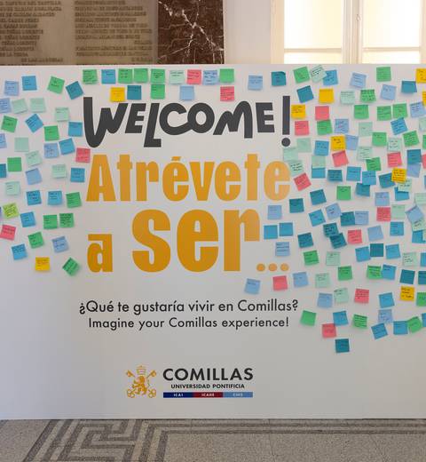Un panel con un mensaje de bienvenida y numerosos post-it de colores, en un evento en la Universidad Pontificia Comillas.