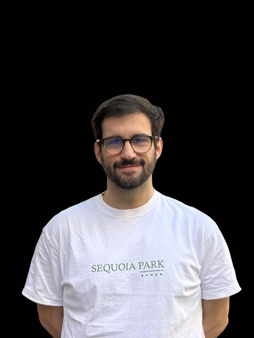 Un hombre sonriente lleva una camiseta blanca con el texto 'Sequoia Park'.