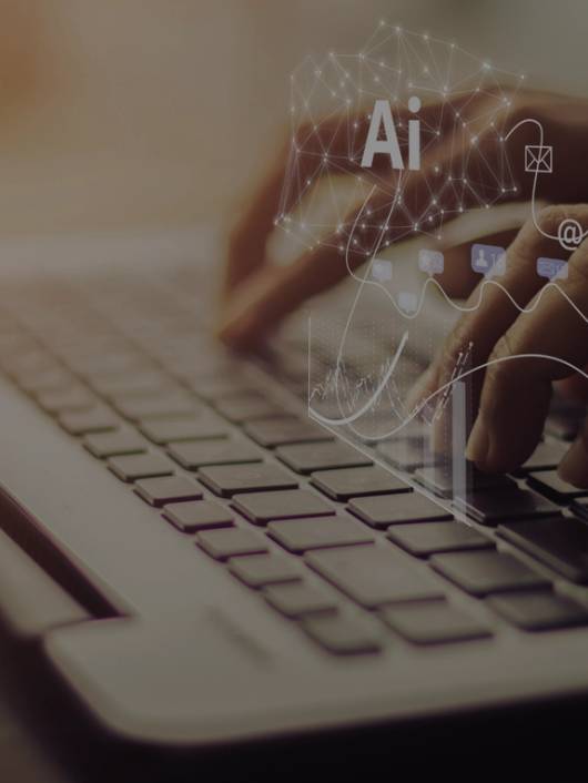 Una persona utiliza un ordenador portátil mientras interactúa con elementos gráficos relacionados con inteligencia artificial.