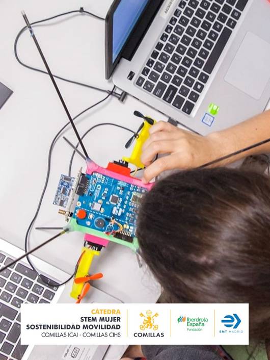 Una persona trabaja en un proyecto de robótica utilizando componentes electrónicos en una mesa de trabajo.