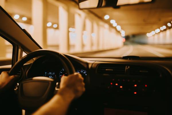 Una persona conduce un coche a través de un túnel iluminado.