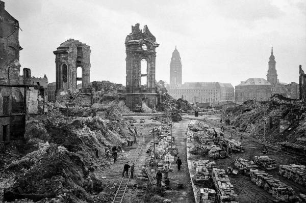 Una vista de un paisaje urbano en ruinas, con edificios destruidos y escombros en el suelo.