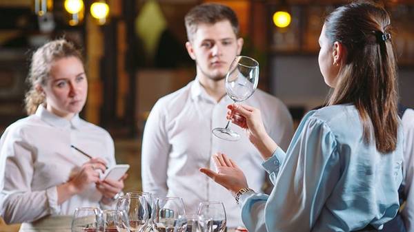 Un grupo de personas en un restaurante discuten sobre cristalería.