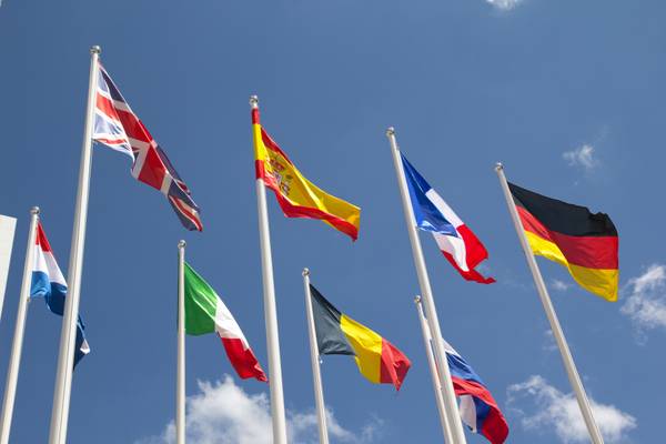 Una fila de banderas de diferentes países ondeando bajo un cielo azul.
