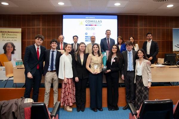 Grupo de estudiantes celebrando un torneo de debate en un auditorio.