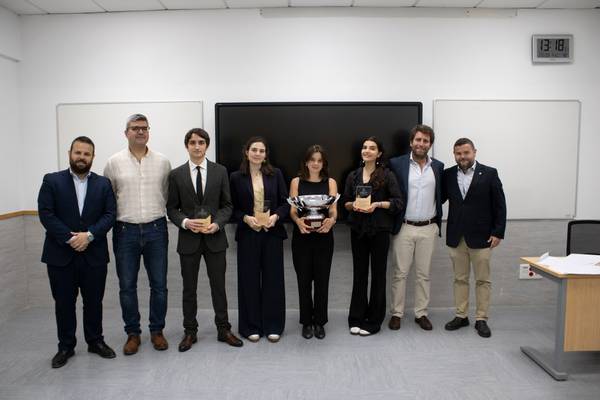 Un grupo de personas posando en un evento de premiación con trofeos en sus manos.
