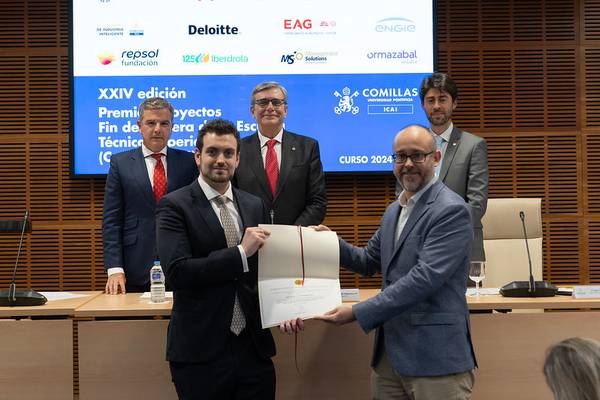Un grupo de personas en un evento de premiación, donde un homenajeado recibe un certificado de manos de un presentador.