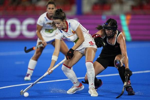 Dos jugadoras de hockey sobre césped en plena competencia por el control del balón.