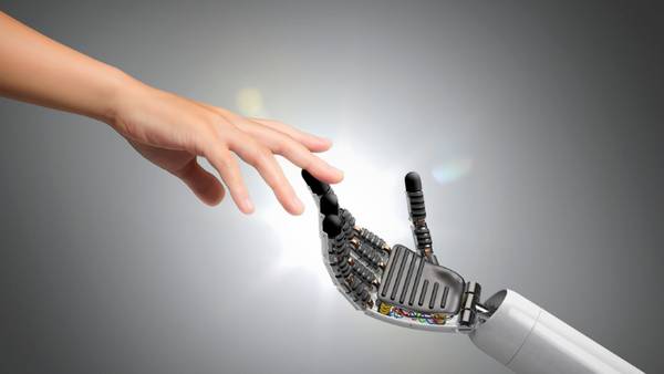 Una mano humana y una mano robótica están a punto de tocarse, simbolizando la conexión entre la humanidad y la tecnología.