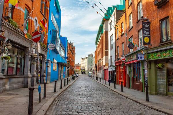 Una calle tranquila y colorida con edificios antiguos y restaurantes en un día despejado.