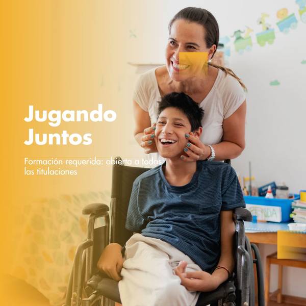 A young smiling boy in a wheelchair with a woman standing behind him, both in a brightly lit room with educational toys.