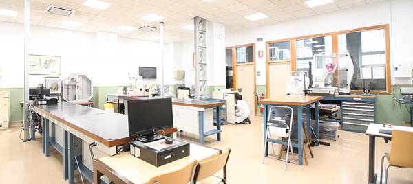 Un laboratorio luminoso y ordenado con mesas de trabajo y equipos técnicos.