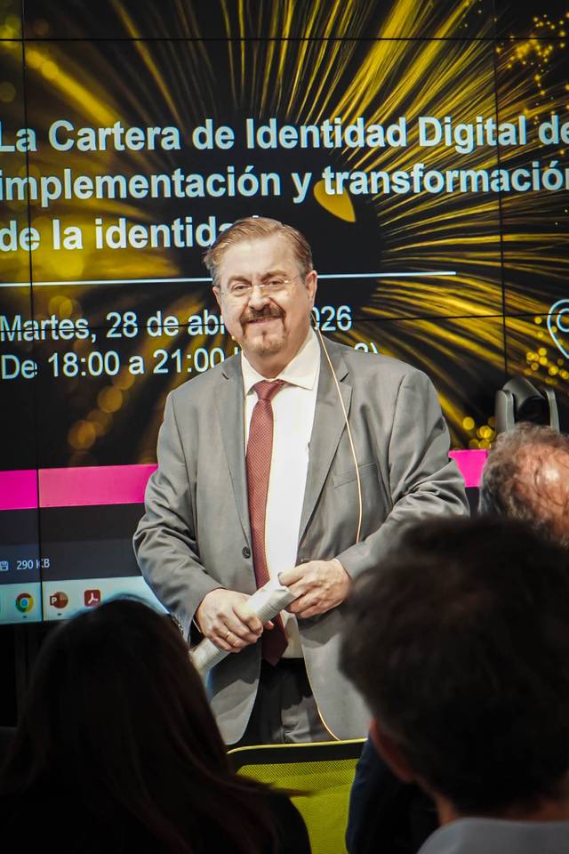Un hombre de negocios habla frente a una presentación sobre la identidad digital.
