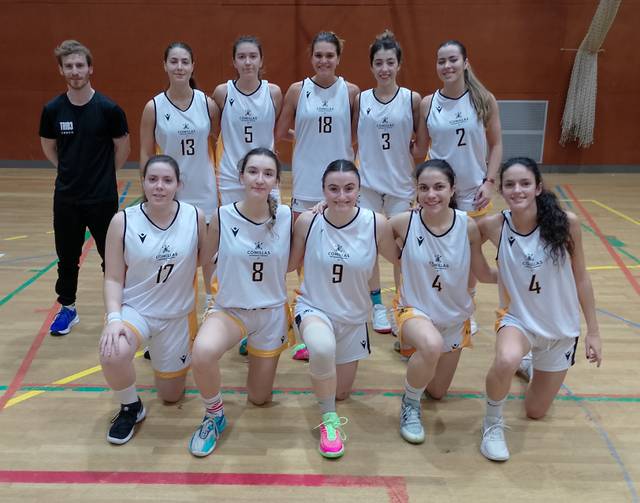 Un equipo de baloncesto femenino posando en una cancha.