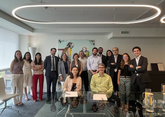 Un grupo de personas sonrientes posando en una sala de reuniones moderna.