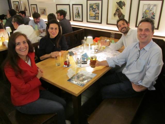 Four people smiling at a table in a restaurant.