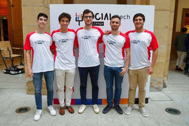 Five young men standing together wearing white and red t-shirts with the logo 'iSOCIALMtech'.