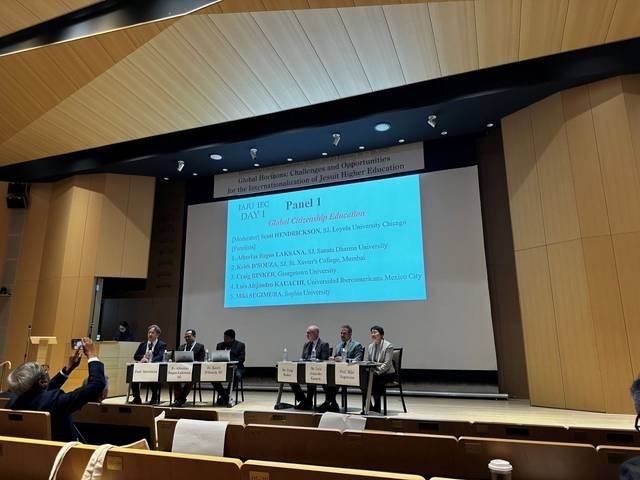 Imagen de un panel de discusión en una conferencia sobre educación superior con varios ponentes en una mesa.