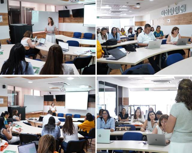 Una mujer está presentando frente a un grupo de personas en un aula moderna.