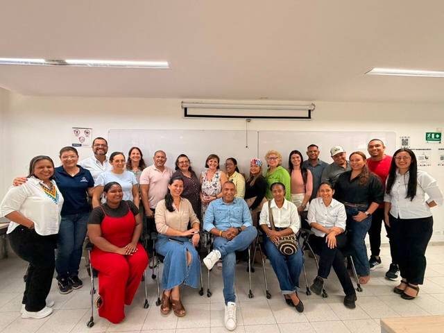 Grupo de personas posando juntas en un aula.