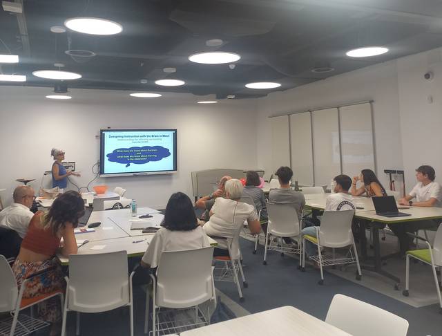 Una sala de reuniones donde un grupo de personas asiste a una presentación.