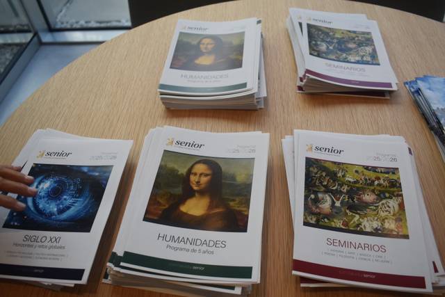 Una mesa con varios folletos apilados sobre temas variados como arte y humanidades.