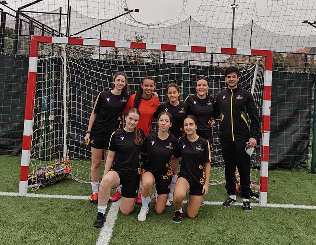 Grupo de jugadoras de fútbol posando frente a la portería después de un partido.