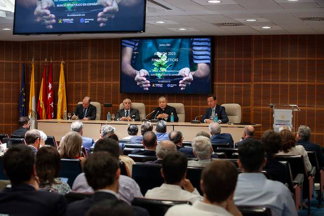 A panel discussion taking place in a conference room with an audience and four panelists, showcasing a presentation with the theme 'Business Ethics'.