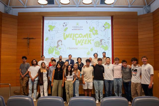 A group of young people standing in a room with a 'Welcome Week' banner in the background.